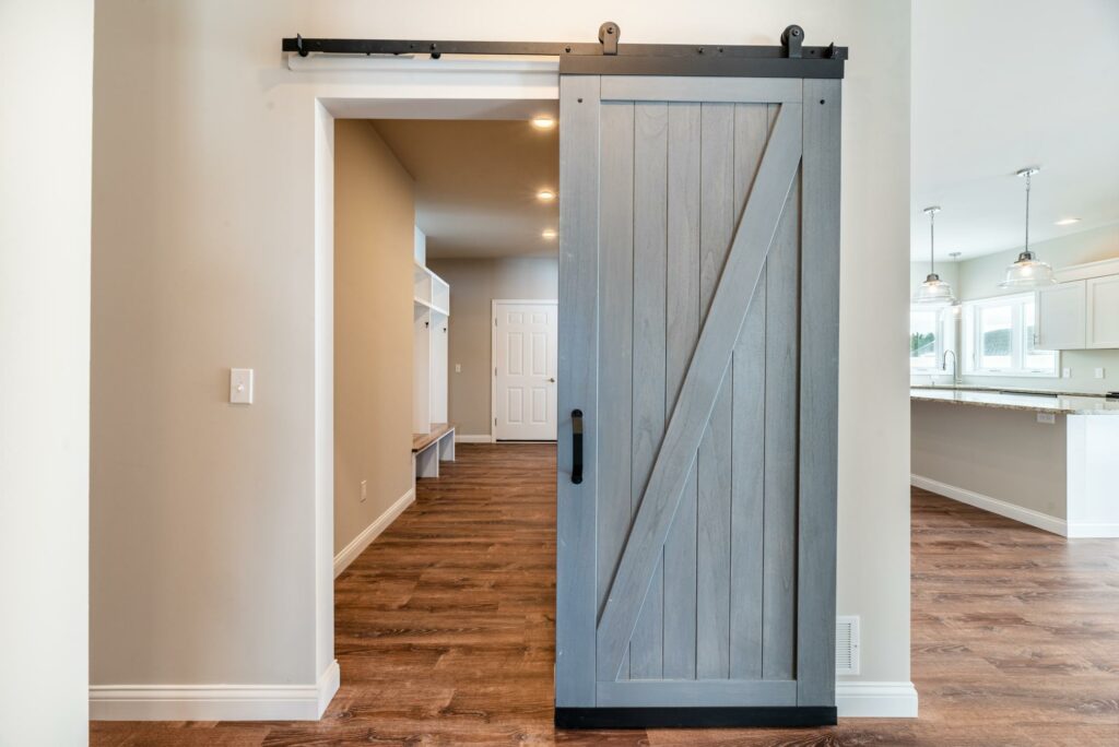 Gray barn door opening to a bright family hallway